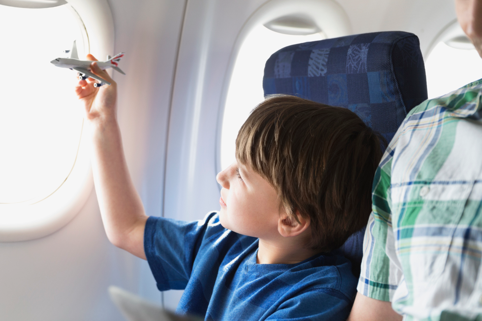 Garçon jouant avec un avion-jouet à bord d’un avion