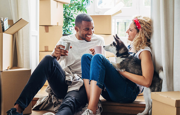 Young couple and dog enjoying a break from moving into their new home.