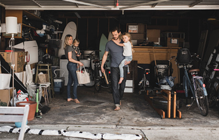 Young family tidying up a messy garage.
